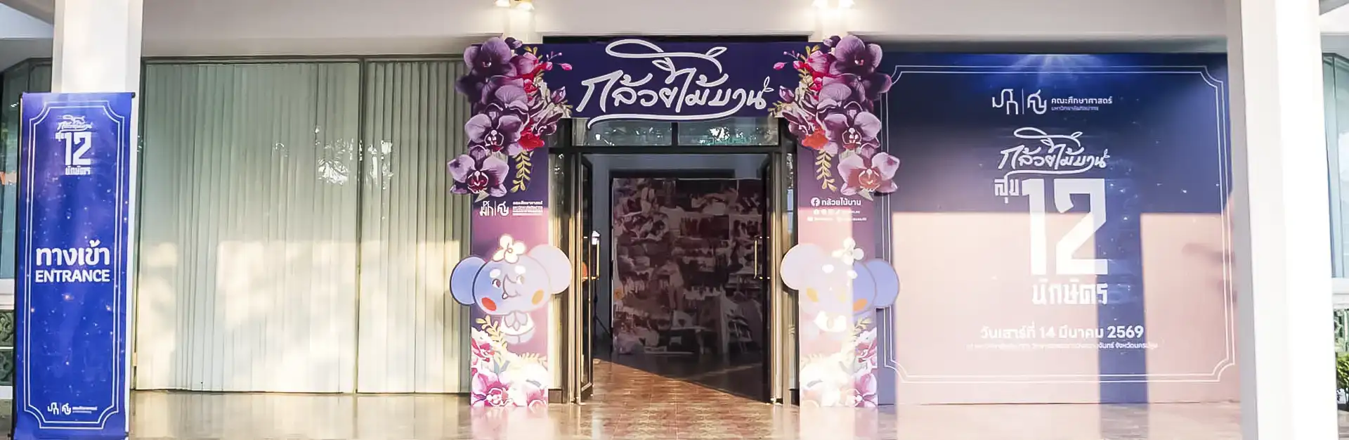 ภาพแบนเนอร์ซุ้มประตูทางเข้างานกล้วยไม้บาน 12 นักษัตร และนิทรรศการกล้วยไม้แห่งกาลเวลา (Orchid Diary) ณ เรือนกระจก ศูนย์ศิลปวัฒนธรรมเฉลิมพระเกียรติ 6 รอบพระชนมพรรษา มหาวิทยาลัยศิลปากร วิทยาเขตพระราชวังสนามจันทร์