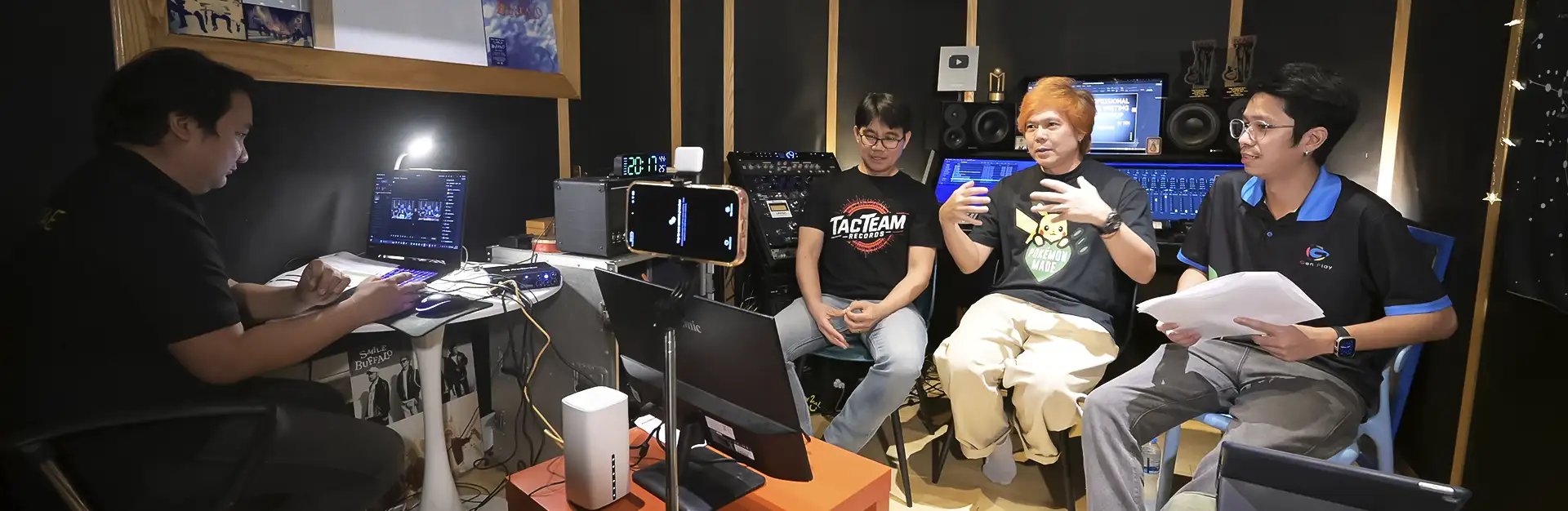 ภาพเบื้องหลังโปรดักชั่น Live เวิร์คช็อปแต่งเพลง Cabal Red แสดงบรรยากาศขณะ พี่เต็น ธีรภัค และ พี่บี TACTEAMRECORDS กำลังพูดคุยแชร์เทคนิคโปรดิวเซอร์ โดยมีทีมงาน บริษัท แล้วแต่ จำกัด ควบคุมระบบถ่ายทอดสดอย่างใกล้ชิด